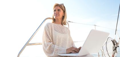 Photo of a woman on a yacht using her laptop