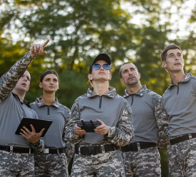 Photo of soldiers flying a drone and looking up