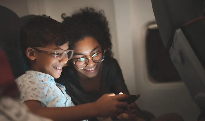 Photo of a mother and kid using a mobile on a plane
