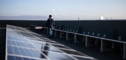 Image of a man walking among solar panels in location