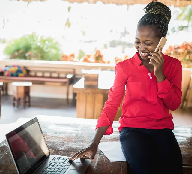 Business woman on phone while using laptop
