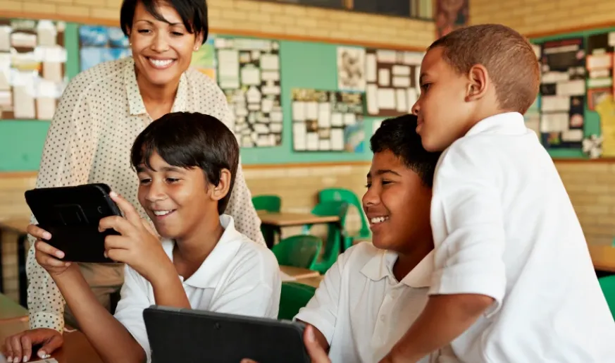 Photo of kids using devices in a classroom