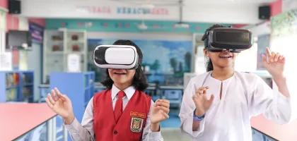 Photo of two students using VR headsets in their classroom