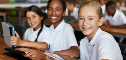 Students smiling, using a tablet