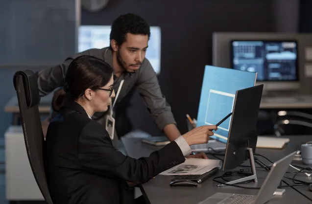 Photo of media employees at their computer
