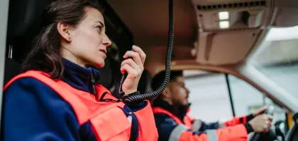 Photo of first responders in their car communicating through radio