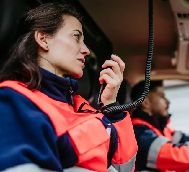 Photo of first responders in their car communicating through radio