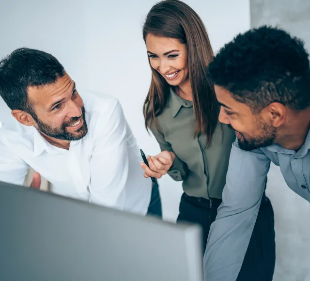 Photo of 3 coworkers around a screen