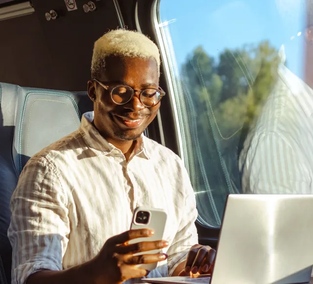 Photo of a man using his mobile while travelling on a train