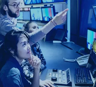 People monitoring multiple screens in a broadcast control room
