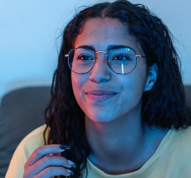 Photo of a woman with glasses watching Television at home