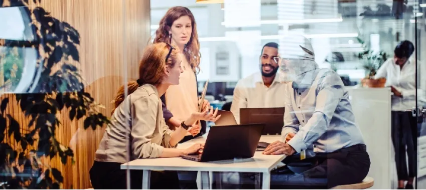 Photo of employees having a business meeting with their laptops