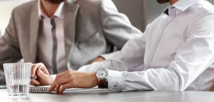 Photo of two corporate people sitting at a meeting 