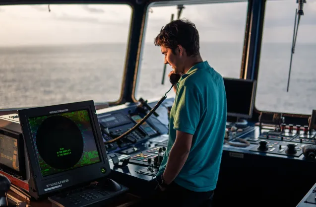 Photo a maritime staff member at sea looking at the boat devices
