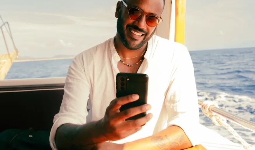 Photo of a man on board a vessel using his smartphone during the voyage