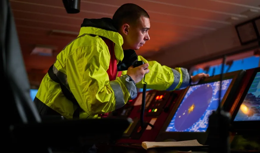 Photo of a captain of a merchant ship navigating during the night