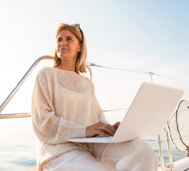 Women of a yacht passenger with her laptop watching the horizon