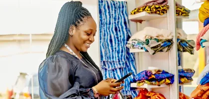 Photo of a woman using her mobile in a clothing store