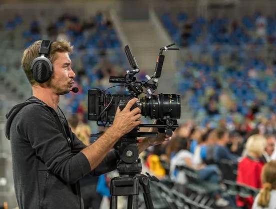 Photo of a cameraman filming sports event