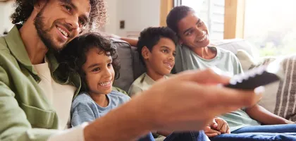 Photo of a father watching TV with sons