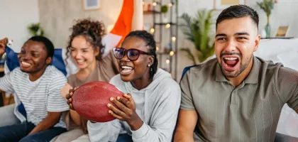 Photo of friends sitting on a couch watching TV