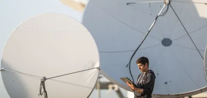 Photo of an engineer with his tablet on a ground location of Eutelsat