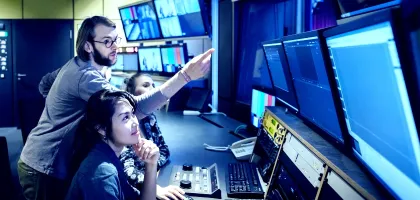 Photo of media engineers working in a control room 